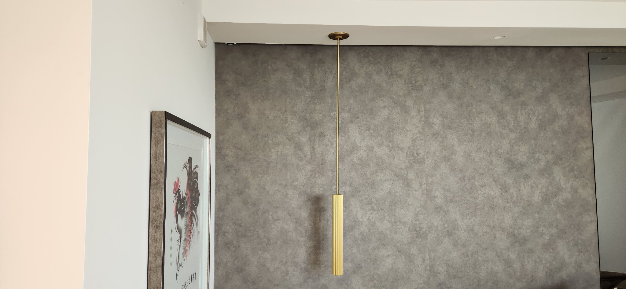 Bathroom with brass pendant light and concrete accent wall