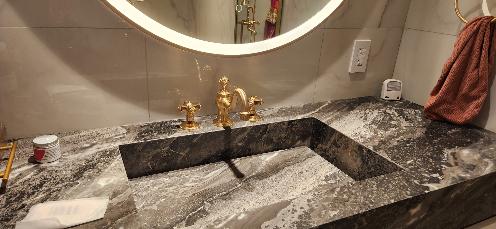 Closeup of marble bathroom vanity with gold faucet