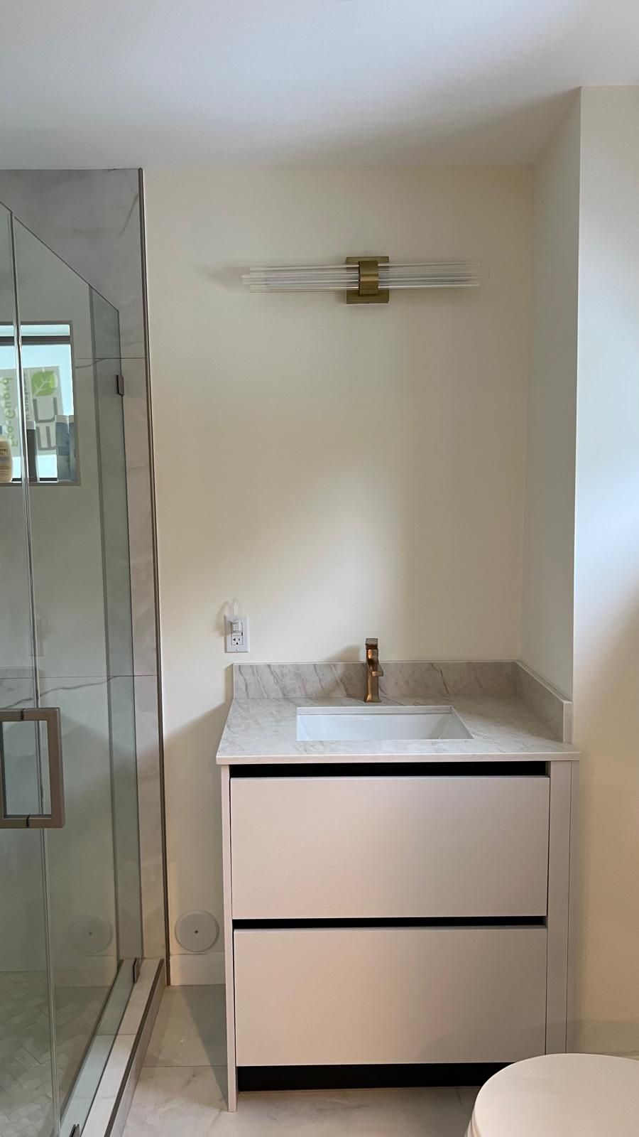 Minimalist bathroom vanity with marble top and brass faucet