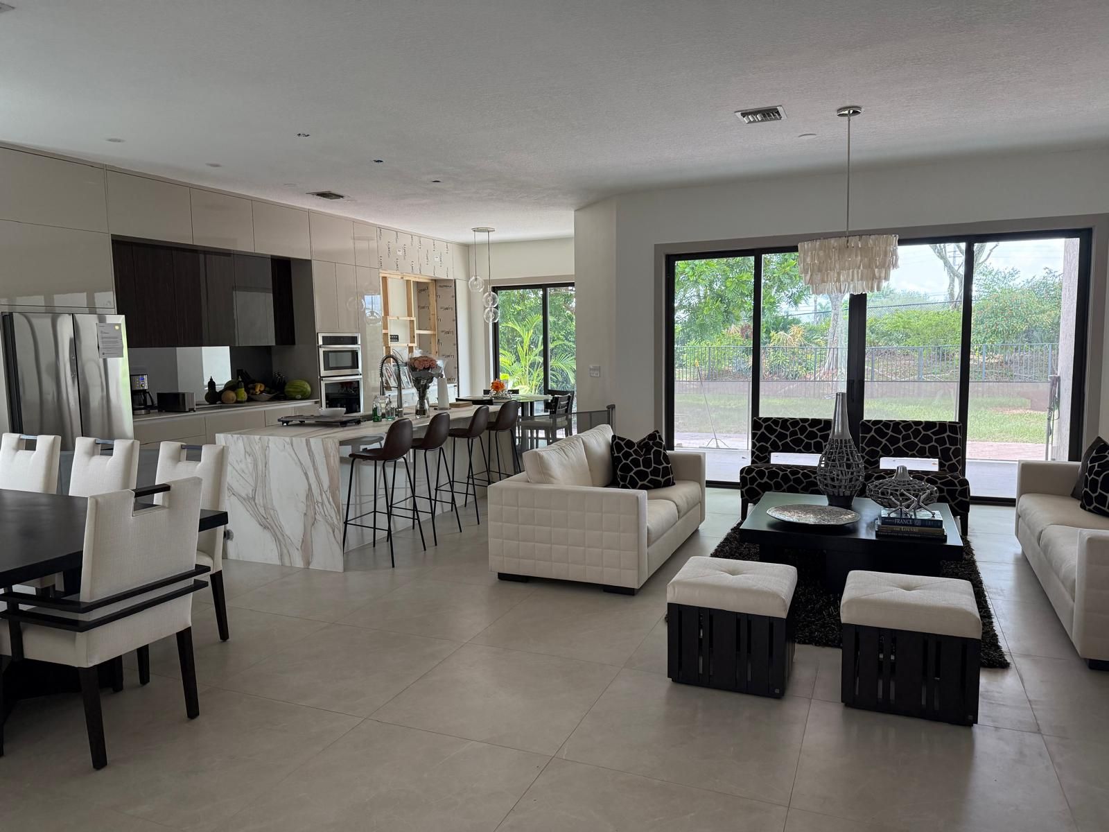 Open-concept living room flowing into kitchen with marble island