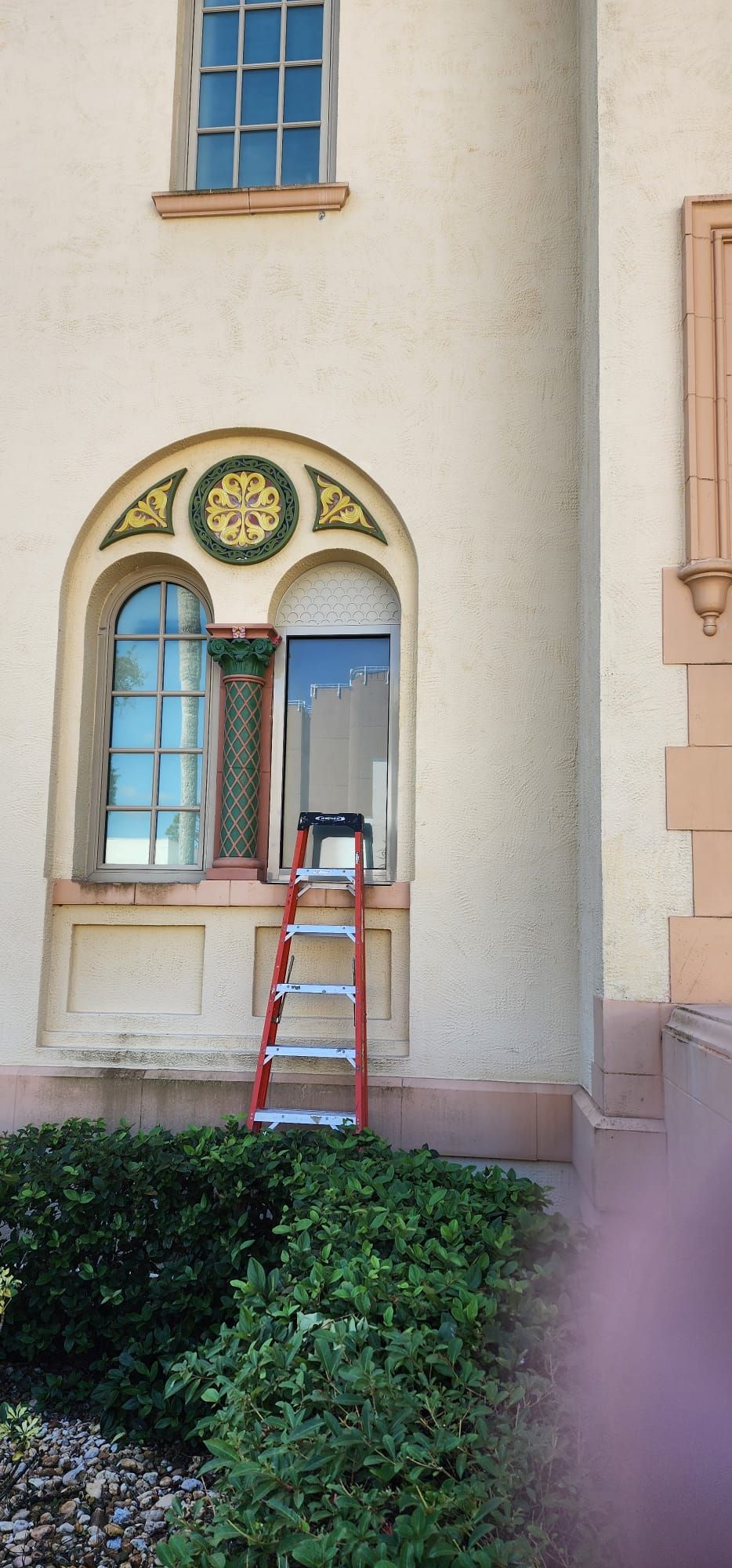 Arched hurricane impact windows installed on a stucco building